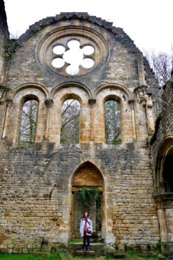 The abbey ruins with a rose window above bay windows and a “door of the dead” leading to the church graveyard
